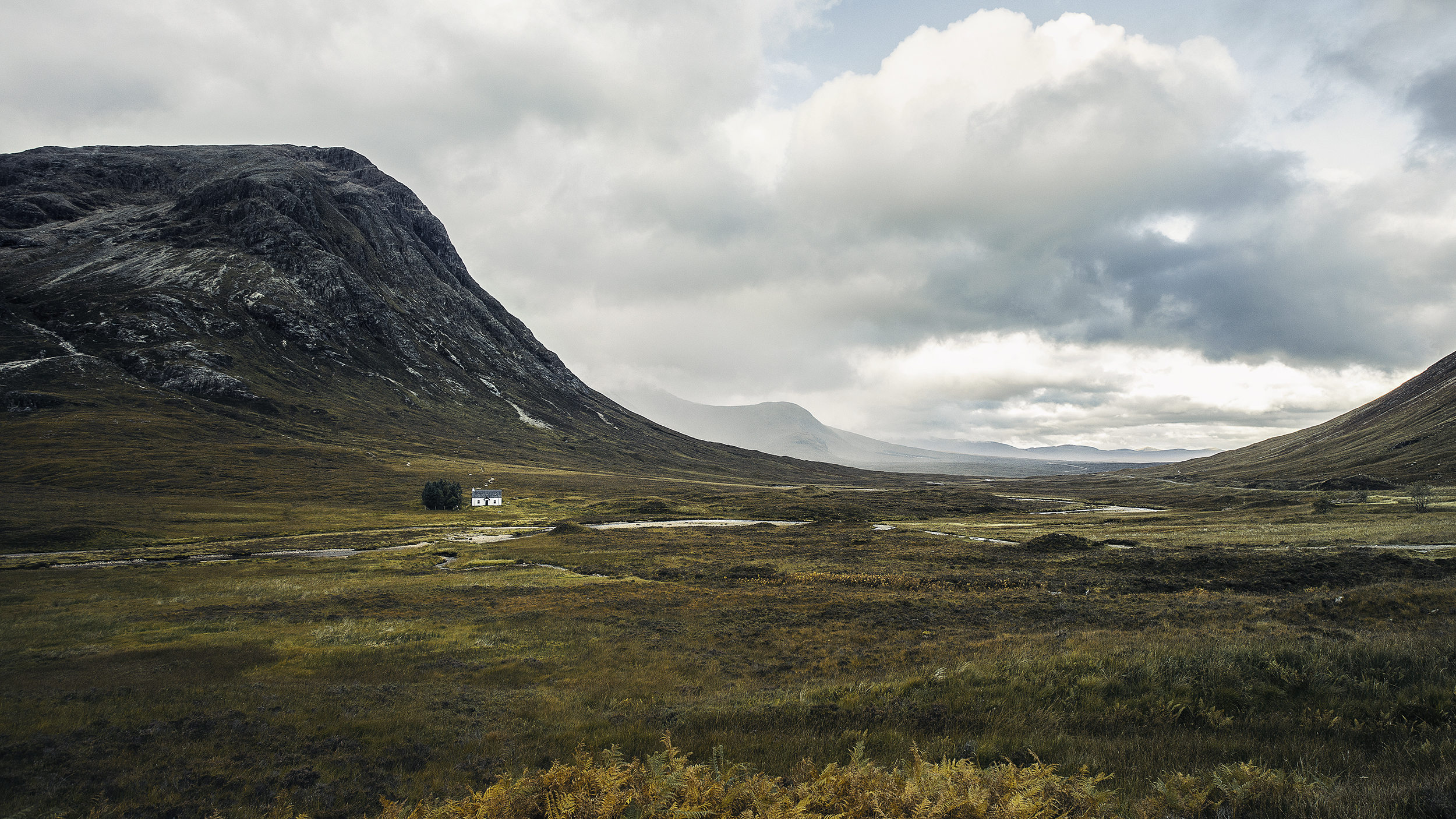 Photo d'une maison écossaise au milieu d'un paysage gigantesque