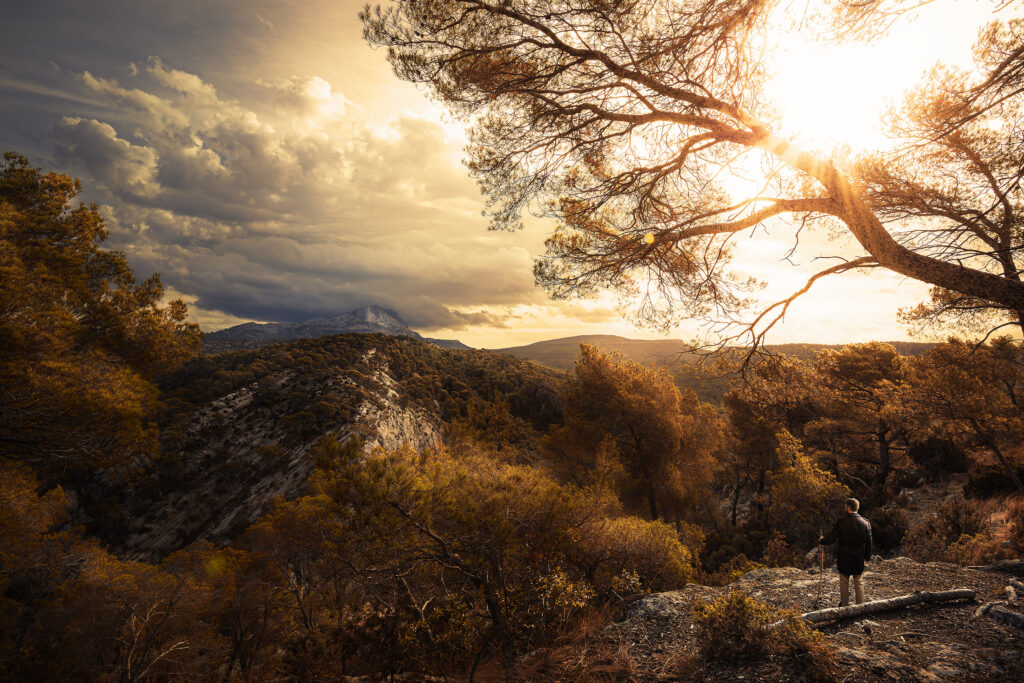 Photo d'une montagne dans le sud de la France lors d'un coucher de soleil, un homme y faisant face