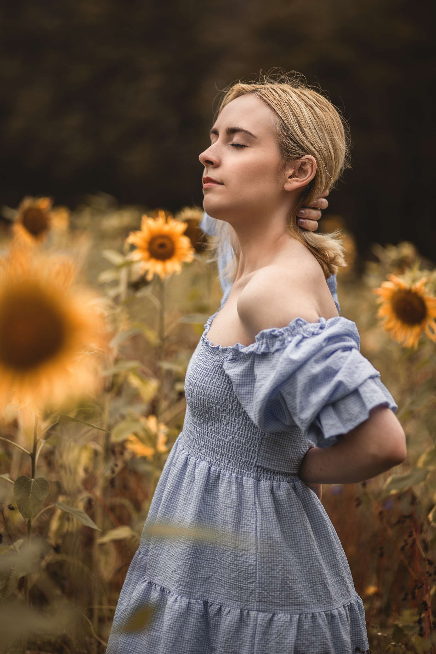 Portrait d'une femme posant au milieu d'un champ de tournesols