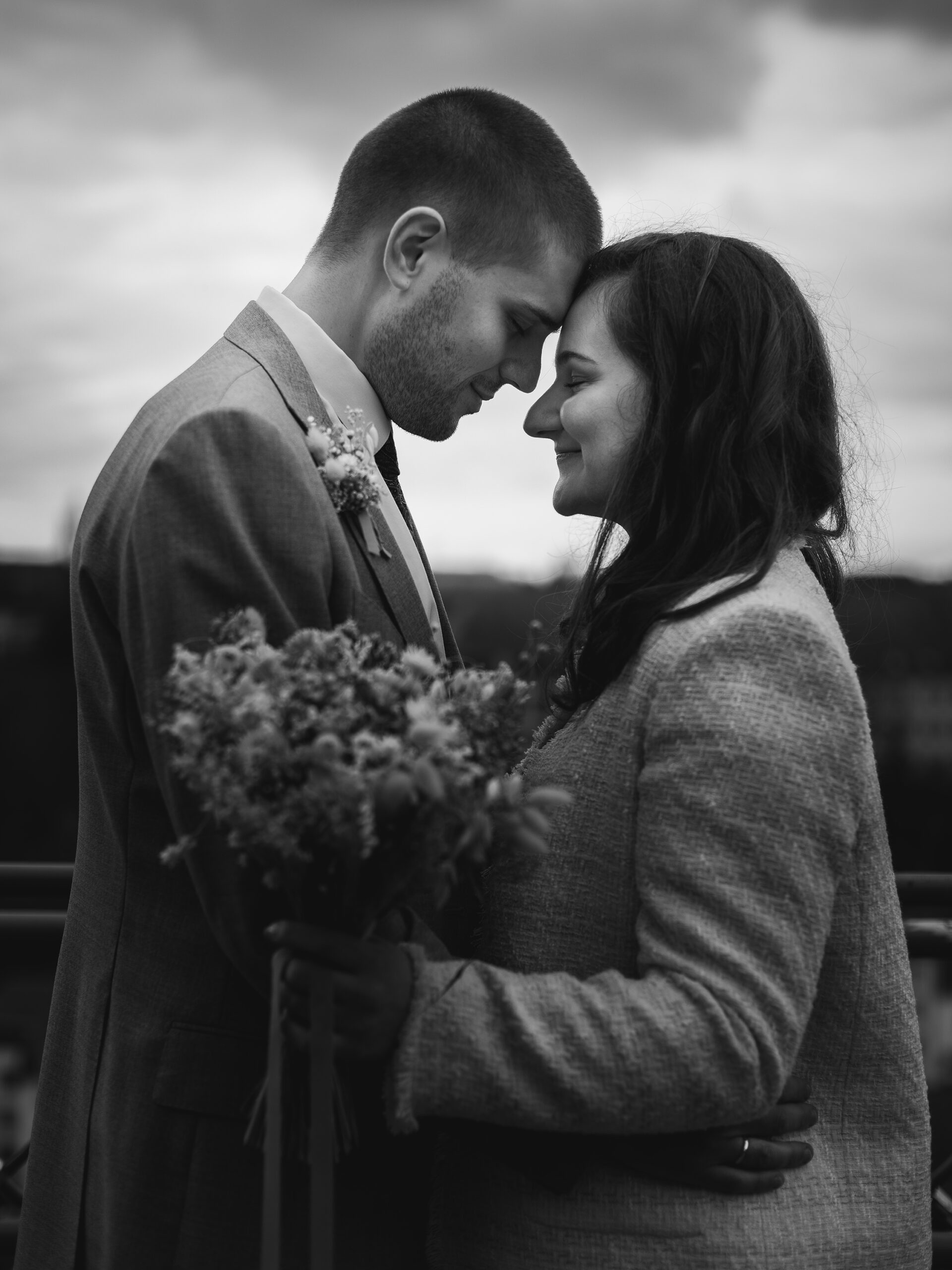 Photo en noir et blanc d'un couple de mariés se tenant dans les bras et fermant les yeux